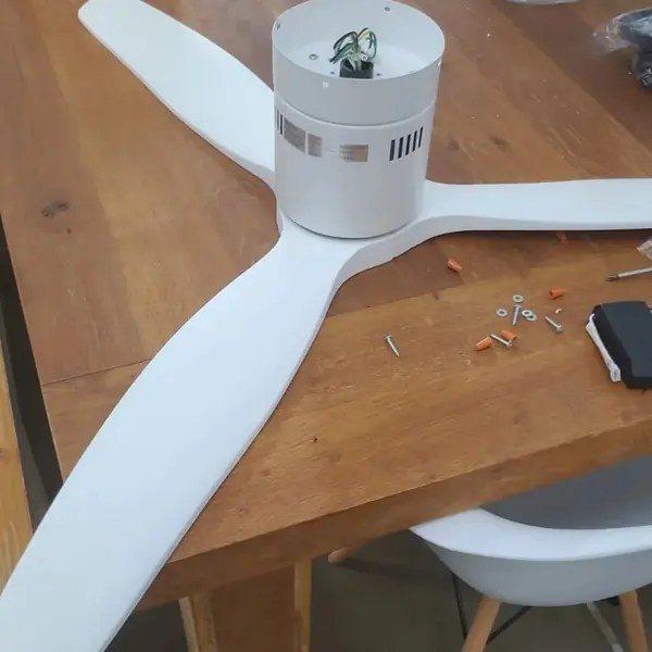 Handyman job: white ceiling fan being assembled on wooden table
