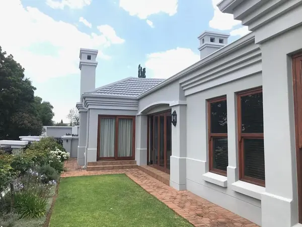 Painting job: grey painted house exterior with wood windows, garden