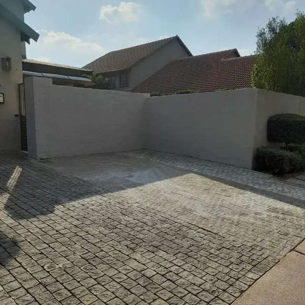 Painting job: painted grey boundary walls around paved driveway
