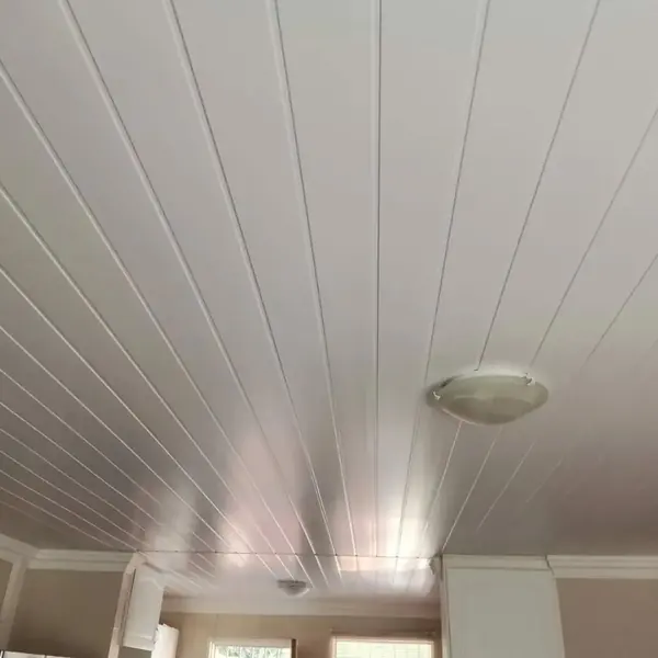 Renovations job: white panelled ceiling with fitting, kitchen cupboards at edge