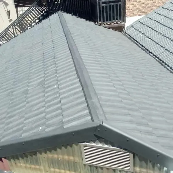 After. Waterproofing job: roof recoated grey with ridge cap and flashing, vent below